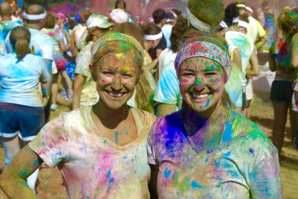 Two women covered in paint after a colour run
