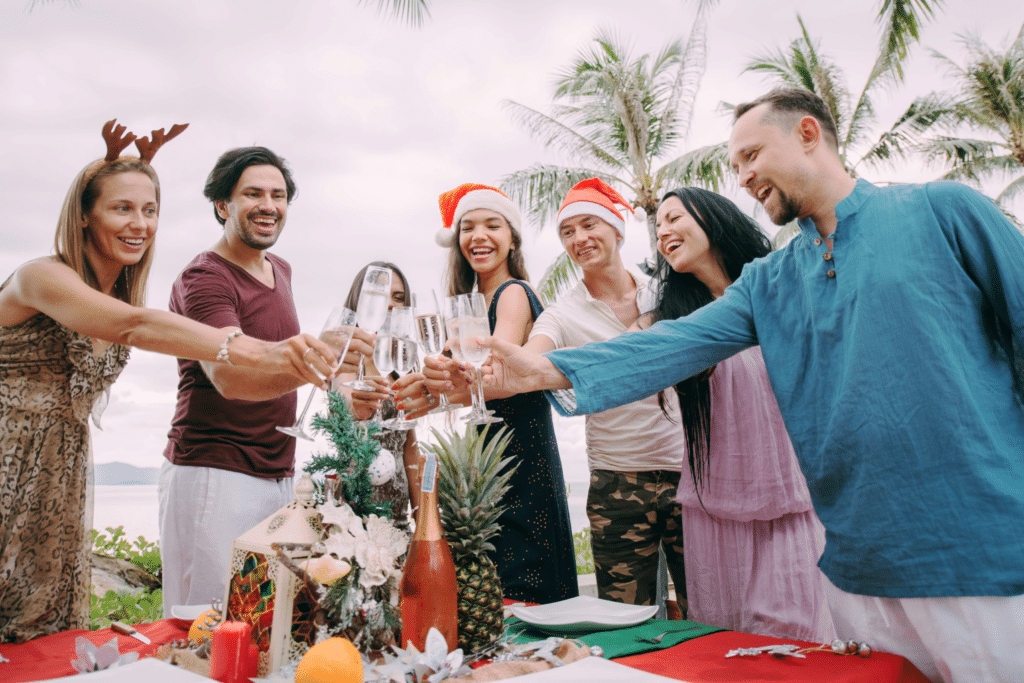 group of people at a christmas-themed party on the beach