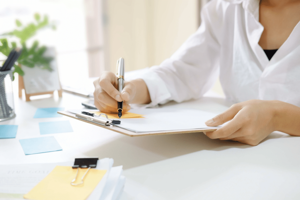 a woman writing on a clipbaord