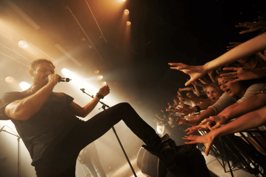 a man performing at a concert with screaming fans