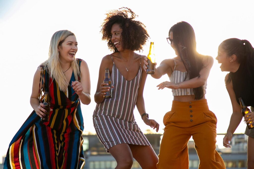 four girls dancing outside at a summer party