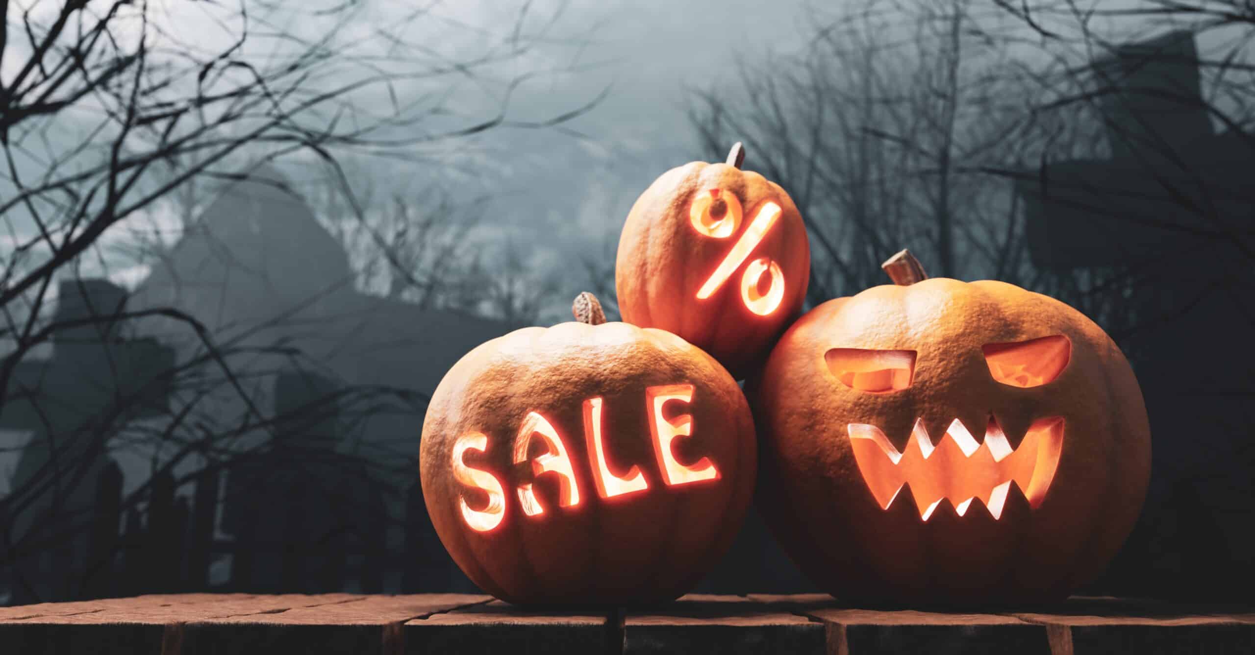 pumpkins carved out with sale signs 